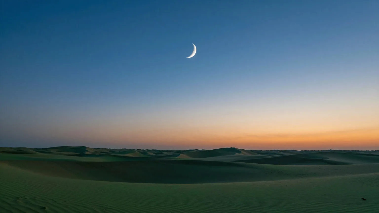Eine schmale Mondsichel über einem ruhigen Wüstenhorizont in der Abenddämmerung, tiefblauer Himmel über orangefarbenem Dünensaum